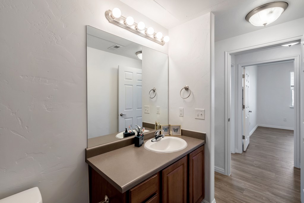 A bathroom with a sink, mirror, and lights.at Florentine Villas, Midvale Utah