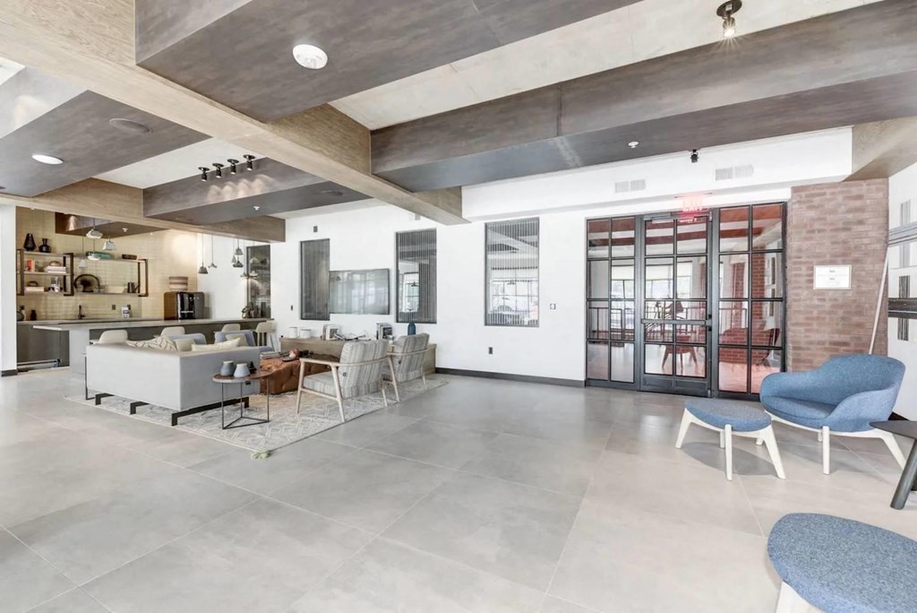the lobby of a building with a living room and a kitchen