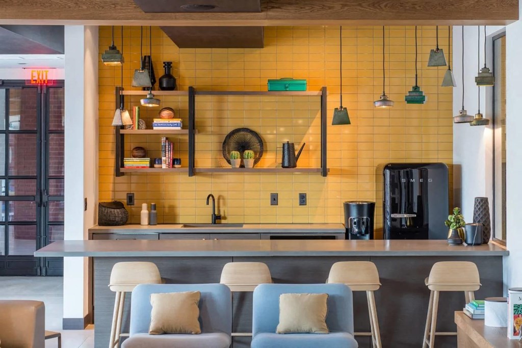 the kitchen and dining area of a modern house with yellow tiles