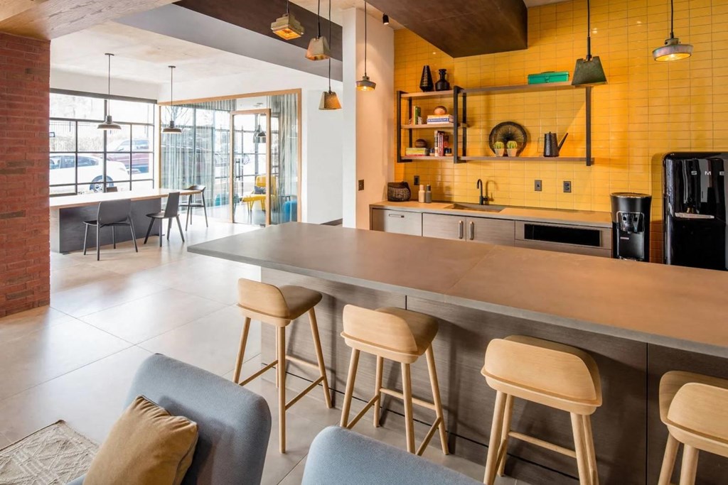 the kitchen and dining area of a modern house with yellow walls