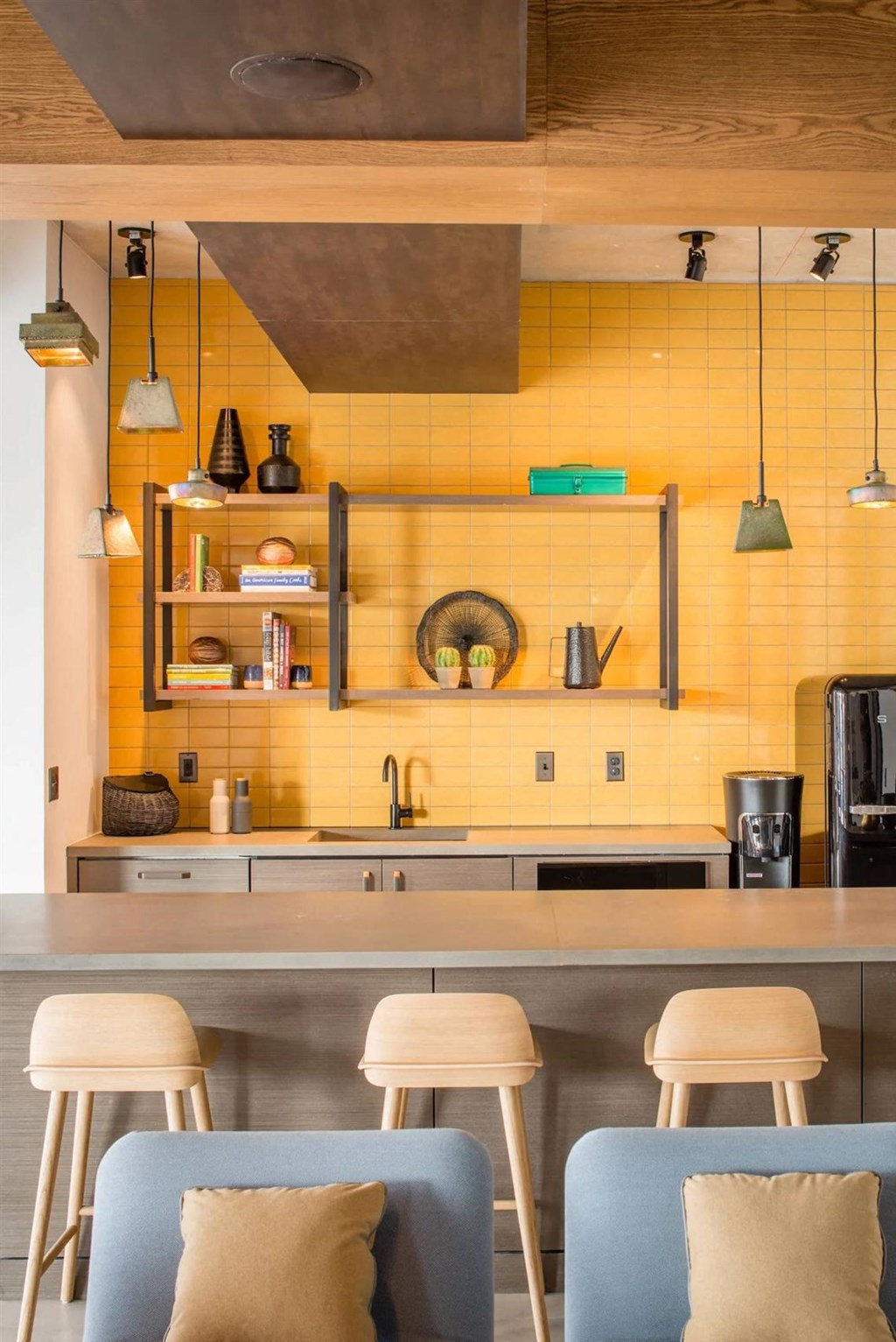 a kitchen with yellow tiles and bar stools