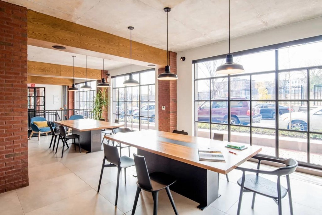 a dining room with tables and chairs and large windows