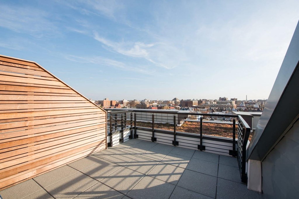 a balcony with a view of a city and a wooden fence