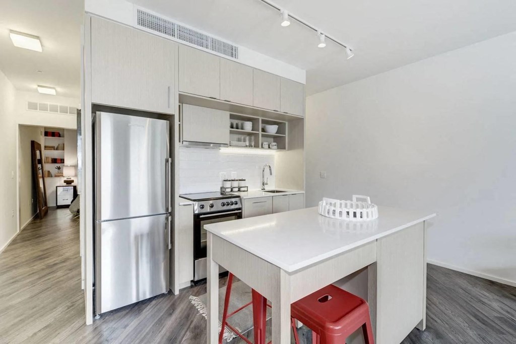 a kitchen with a white counter and a refrigerator