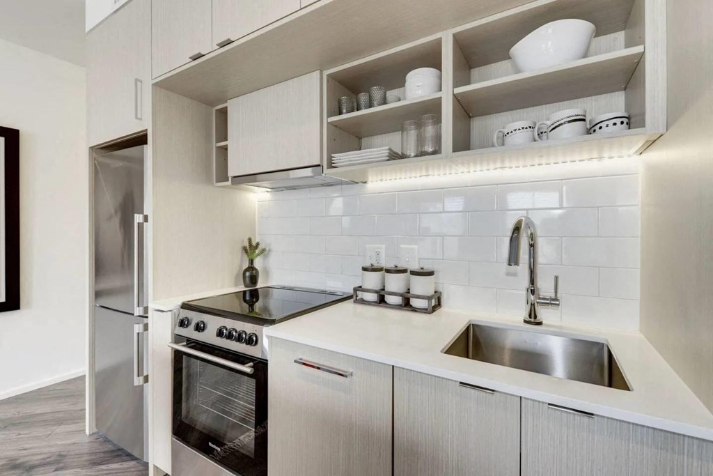a white kitchen with a sink and a refrigerator