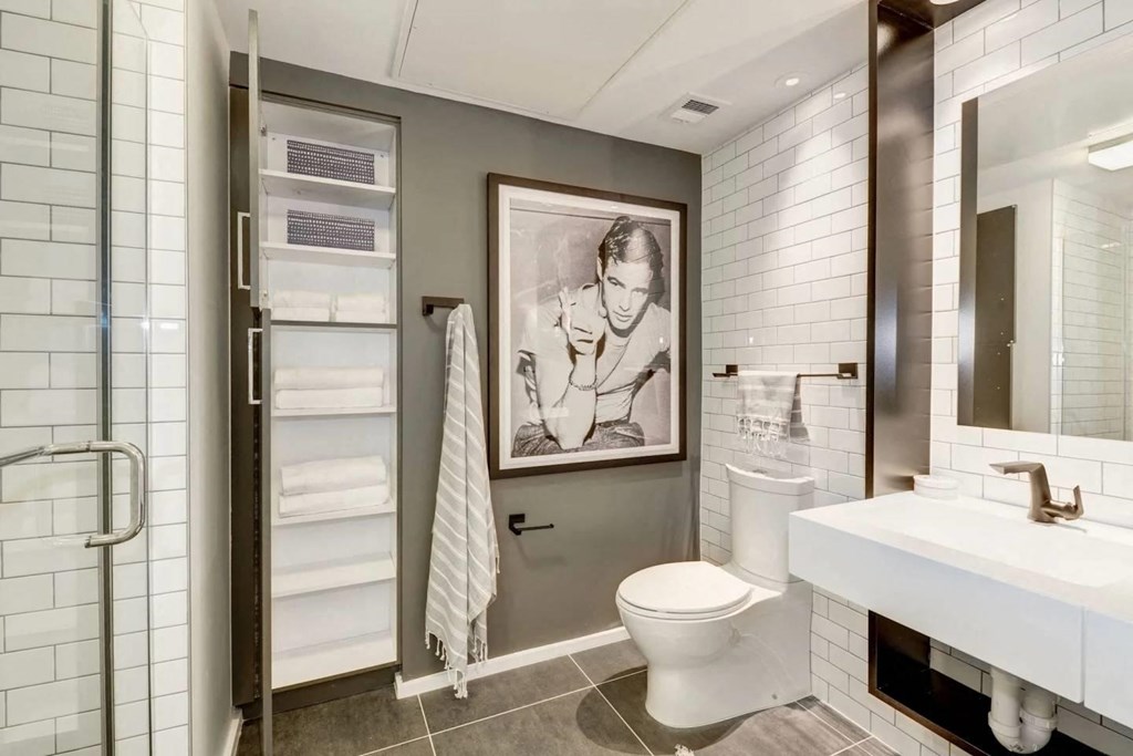 a bathroom with a toilet and a painting on the wall