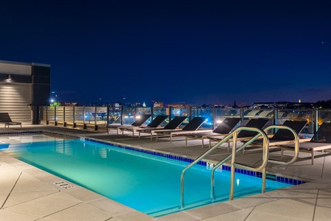 a swimming pool on the roof of a building at night at Coda at Bryant Street, Washington, 20002