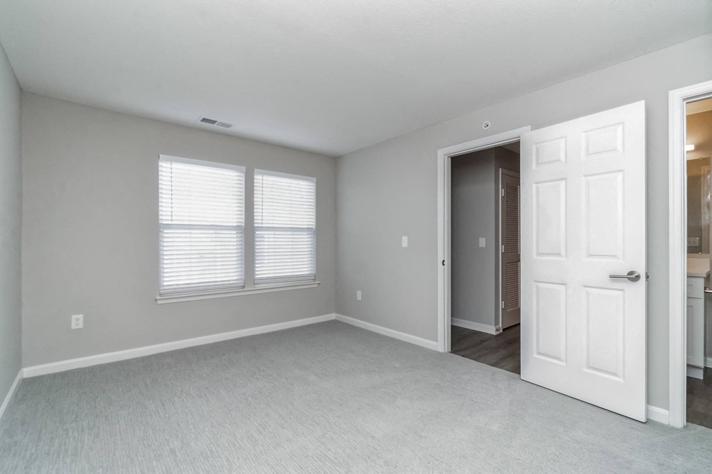 an empty bedroom with a white door and window at The Fields at Lorton Station, Lorton, VA
