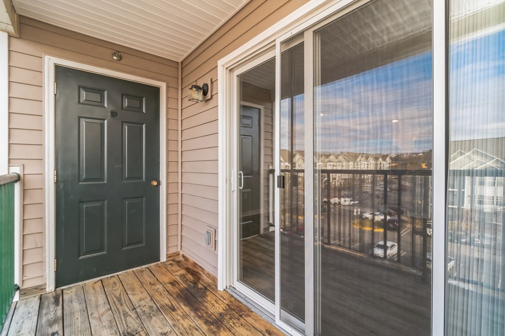 the front porch of a home with a black door and a balcony at The Fields at Lorton Station, Lorton, 22079