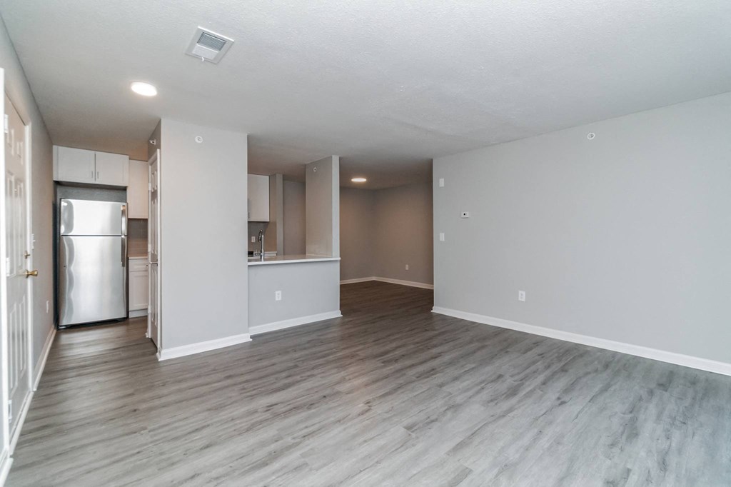an empty living room and kitchen with a refrigerator and at The Fields at Lorton Station, Lorton, 22079