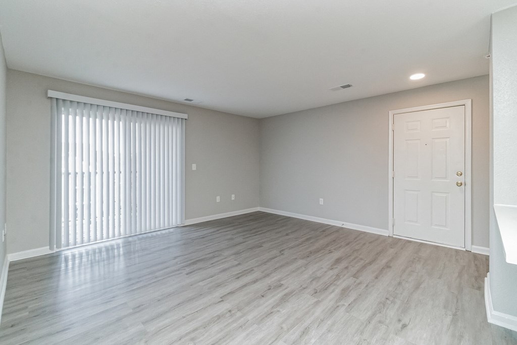 an empty living room with a large window and a door at The Fields at Lorton Station, Lorton, Virginia