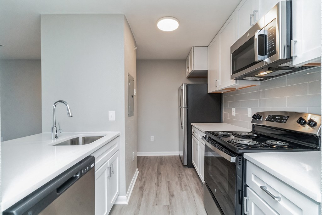 an empty kitchen with white cabinets and stainless steel appliances at The Fields at Lorton Station, Virginia, 22079