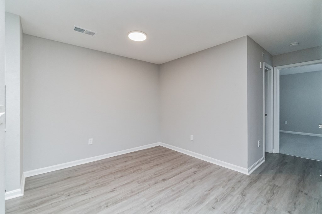 an empty living room with wood floors and grey walls at The Fields at Lorton Station, Lorton, VA