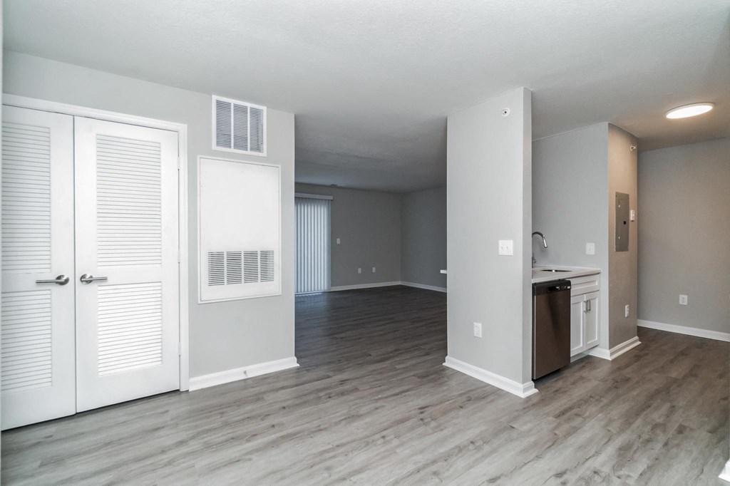 an empty living room with white doors and a kitchen at The Fields at Lorton Station, Lorton, 22079