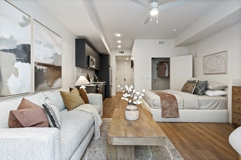 A modern living room with a grey couch, a wooden coffee table, and a large abstract painting on the wall.