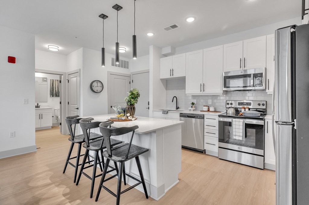 an open kitchen with a large island with three stools at the Riverwalk, Wilmington, NC 28401