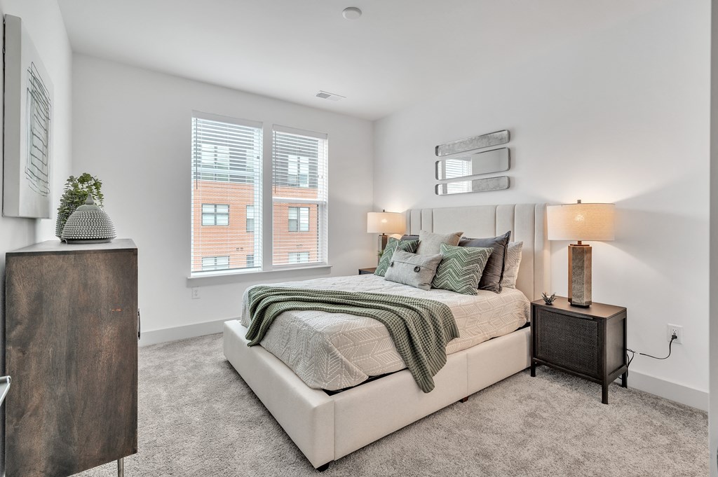 a bedroom with a large bed and two windows at the Riverwalk, Wilmington