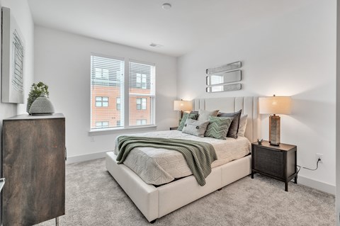 a bedroom with a large bed and two windows at the Riverwalk, Wilmington