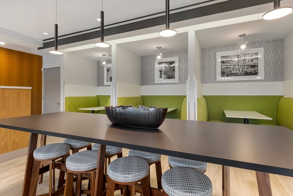 a large table with a black bowl on top of it in a room with green booths and at Delamarre at Celebration, Celebration, FL