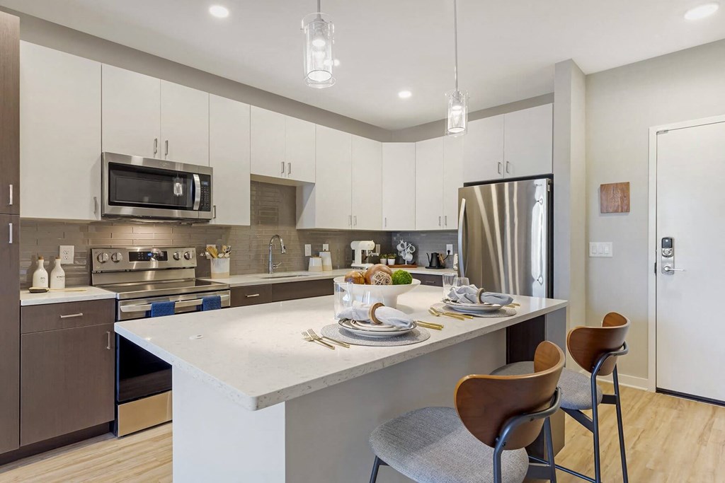 a kitchen with white cabinets and a large island with a white countertop at Delamarre at Celebration, Florida