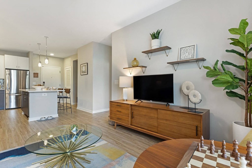 a living room with a large tv and a kitchen in the background at Delamarre at Celebration, Celebration, 34747