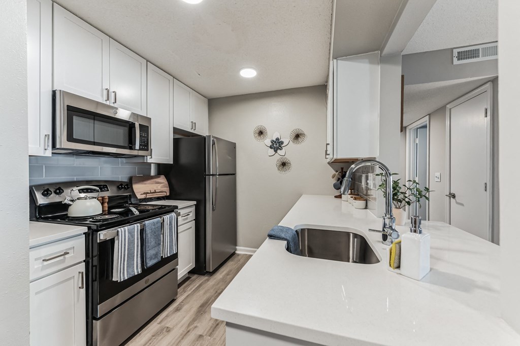 a kitchen with white cabinets and stainless steel appliances at Brampton Moors, Cary, 27513