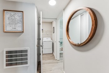 a bathroom with a white washer and dryer and a mirror on the wall - Photo Gallery 15