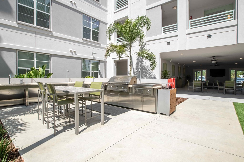 a patio with a grill and tables and chairs at Delamarre at Celebration, Florida, 34747