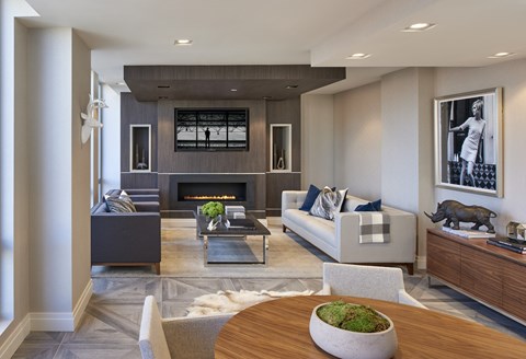 A modern living room with a fireplace and a large painting on the wall.