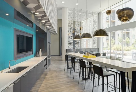 a kitchen with a long counter and a long table with chairs