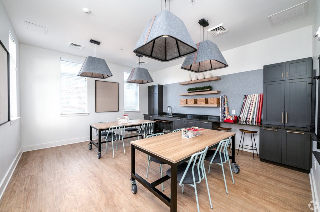 a dining room with tables and chairs and a kitchen at Fairmont at South Lake, Bowie