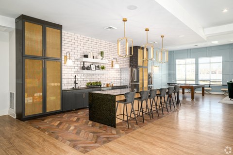 a large kitchen with an island and chairs in front of a dining room