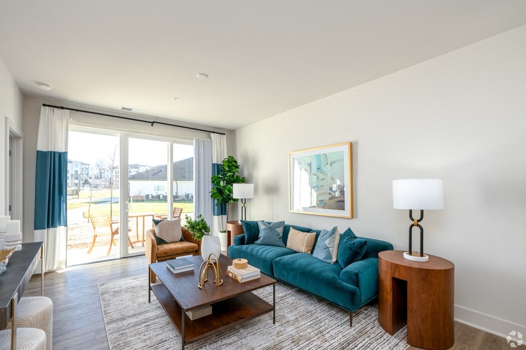 a living room with a blue couch and a sliding glass door at Fairmont at South Lake, Bowie, 20716