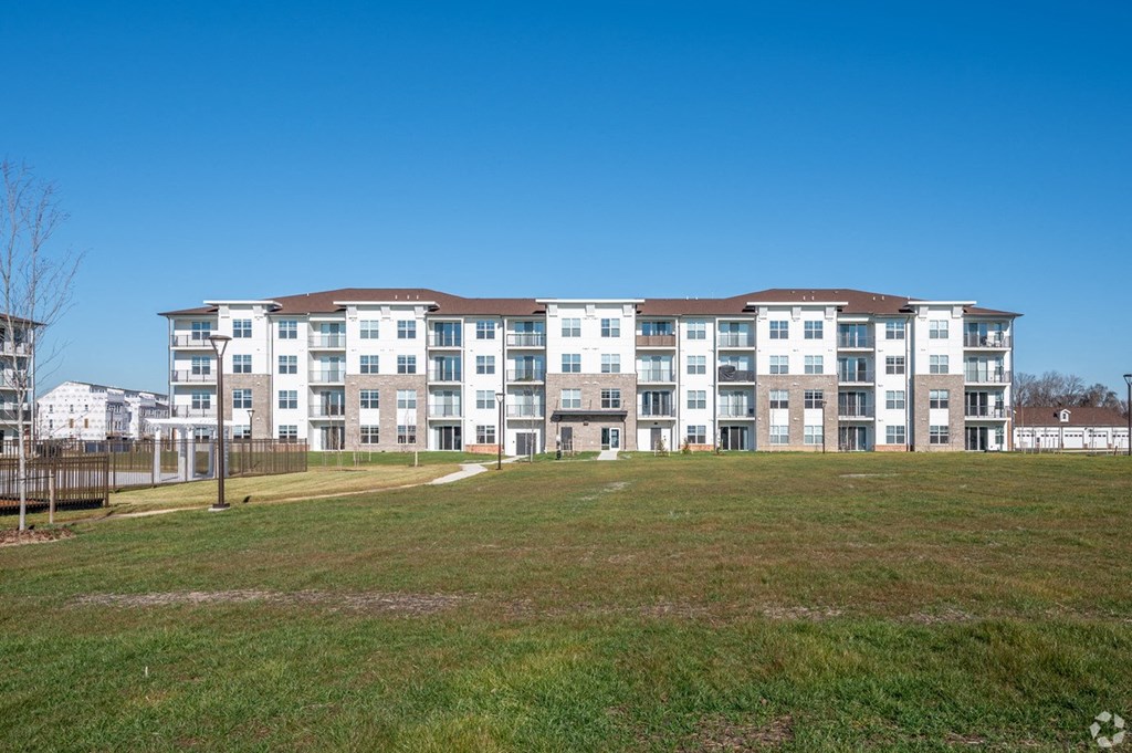a large apartment building on top of a green field at Fairmont at South Lake, Bowie, MD
