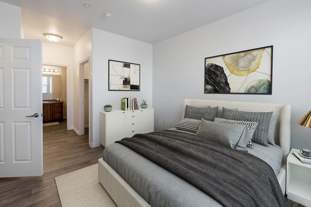 A bedroom with a large bed and a painting on the wall.at Florentine Villas, Midvale Utah
