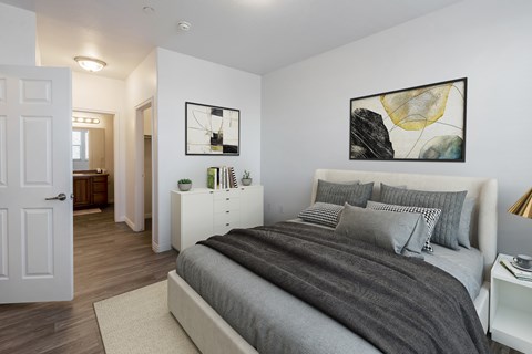 A bedroom with a large bed and a painting on the wall.