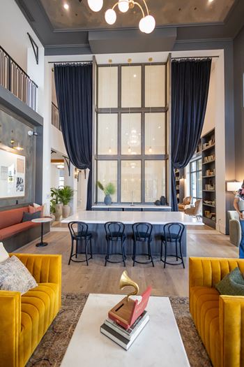 a living room with yellow couches and a table in front of a large window  at La Unión, Tampa, 33605