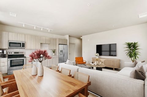 A modern living room with a wooden dining table and a grey sofa.