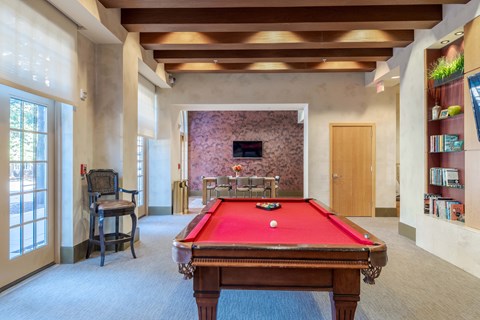 A pool table is in the middle of a room with a chair and a window at Garfield Park, Arlington, 22201