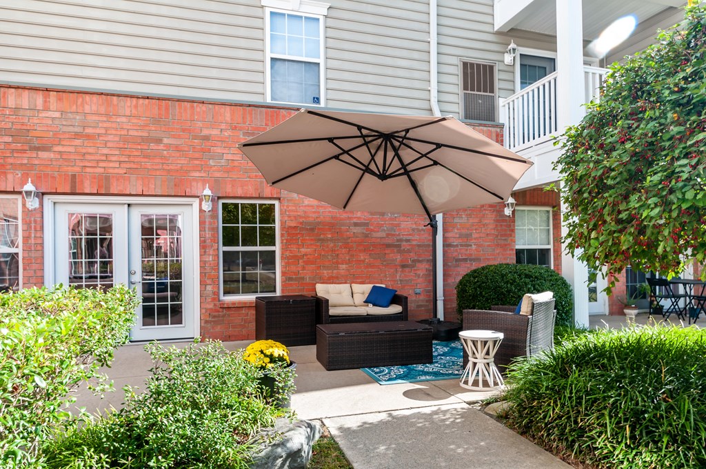 a patio with an umbrella in front of a house