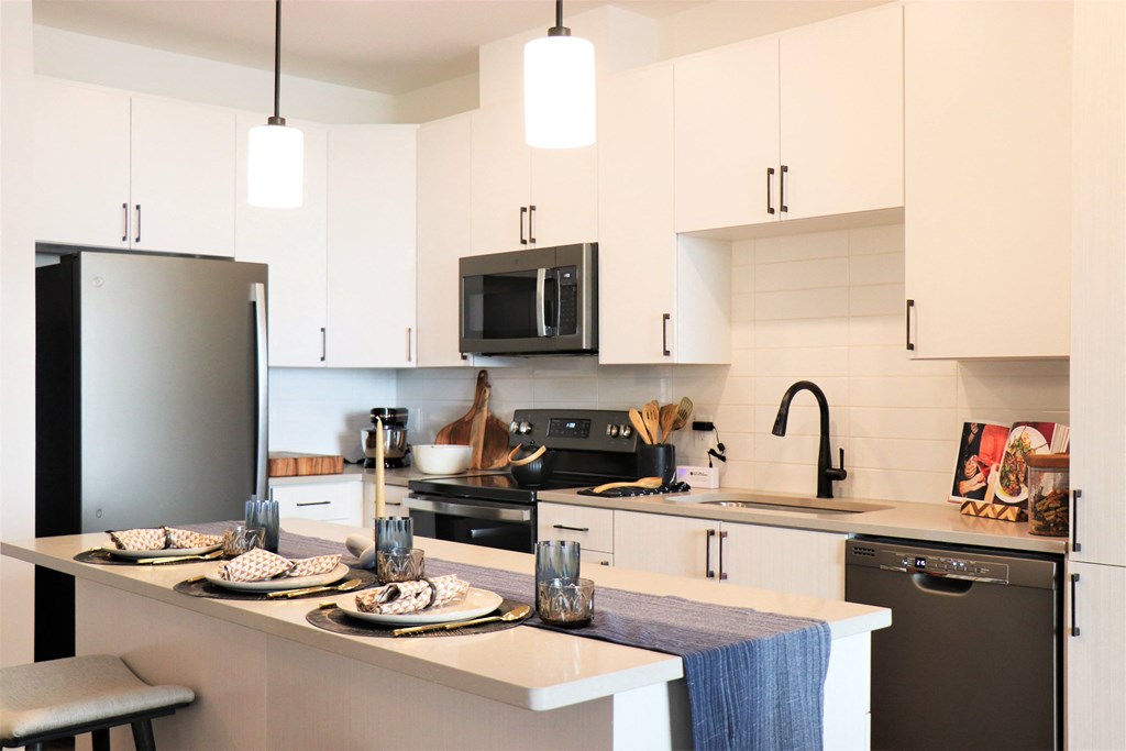 a kitchen with white cabinets and black appliances at Vyne One Loudoun, Virginia, 20147