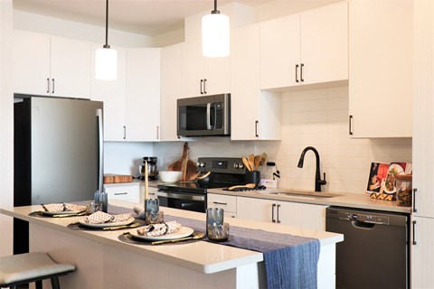 a kitchen with white cabinets and black appliances