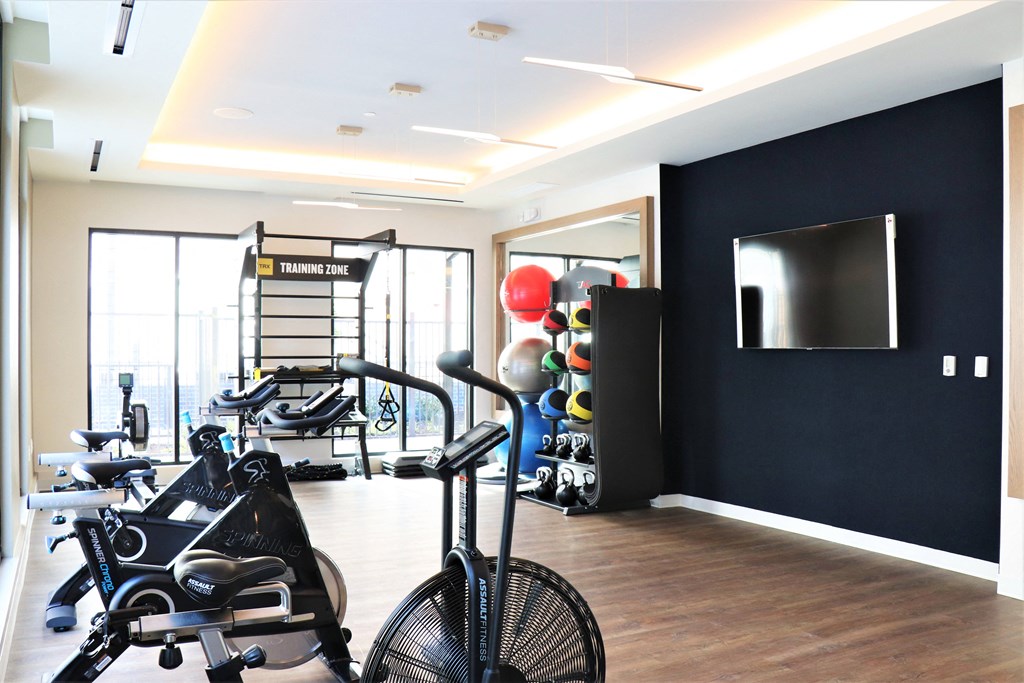 a gym with exercise equipment and a flat screen tv on the wall at Vyne One Loudoun, Virginia