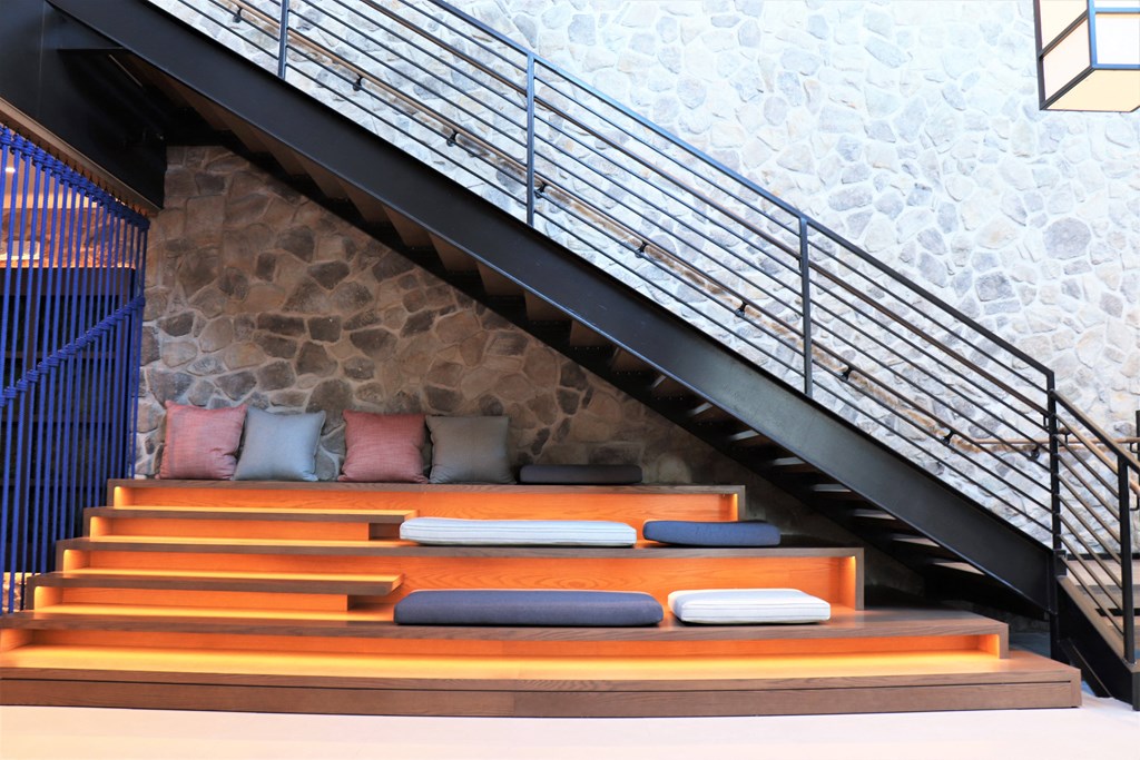 a bench with pillows under the stairs at Vyne One Loudoun, Ashburn, Virginia