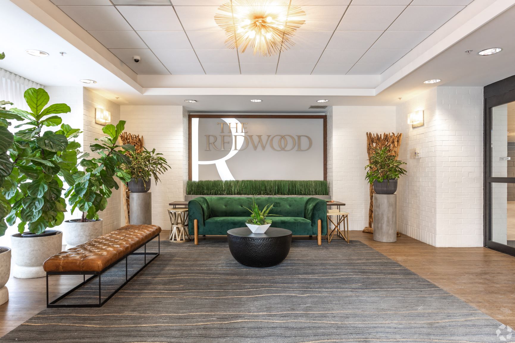 a lobby with a green couch and a large sign that reads the redwood  at The Redwood, Baltimore