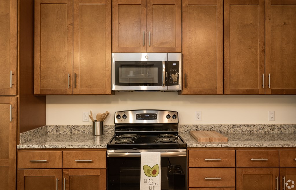 a kitchen with wood cabinets and a stove and a microwave