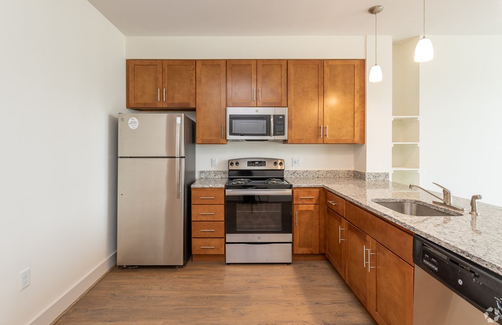 a kitchen with wooden cabinets and stainless steel appliances and granite counter tops
