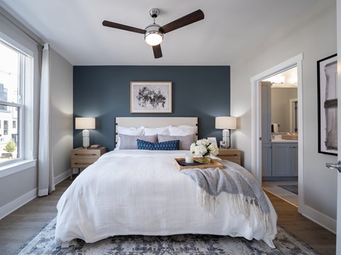 A bedroom with a large bed and a ceiling fan at The Sully Apartments, Chantilly, VA