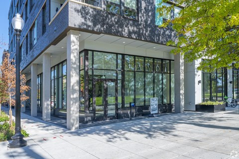 A modern building with a glass facade and a tree in front at Jayde Parkside, District of Columbia, 20019