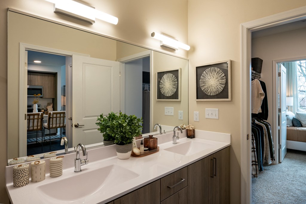 a bathroom with two sinks and a large mirror  at Brentford at The Mile, Tysons